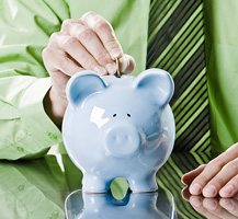 Man putting coins in a piggy bank